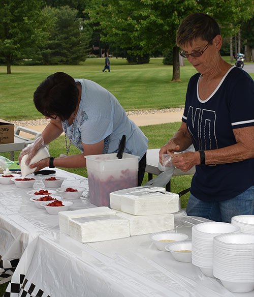 Volunteers serving Strawberry Short Cake at the Father’s Day Car Show